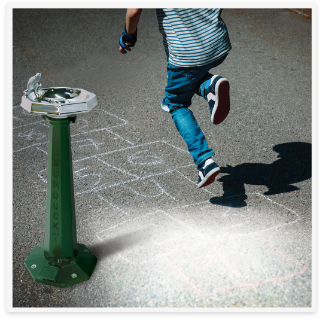 Kid playing by a retro style outdoor drinking fountain