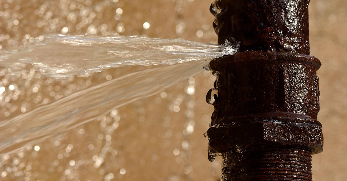 Businesswoman With Laptop Sitting At Desk Keeping Hydrated Drinking From Water Bottle In Office